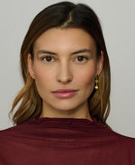 Woman wearing a burgundy top against a plain background