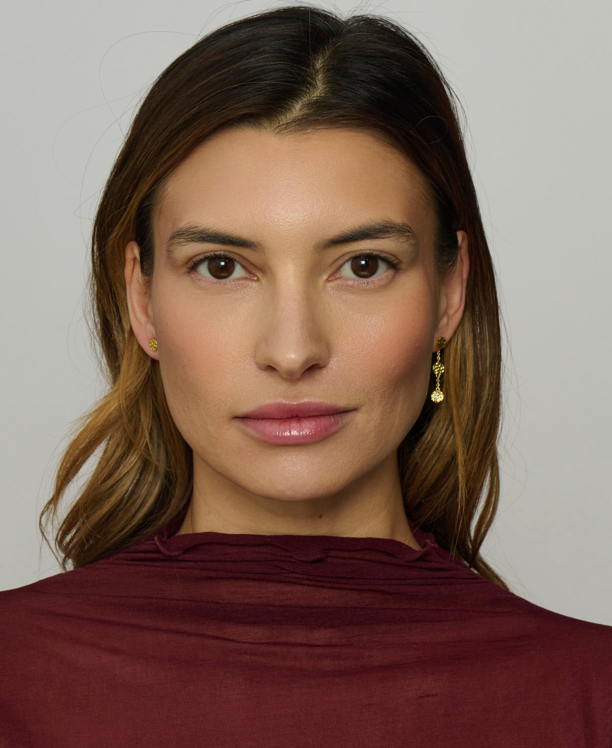 Woman wearing a burgundy top against a plain background