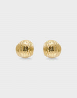 Pair of gold textured earrings on a light gray background