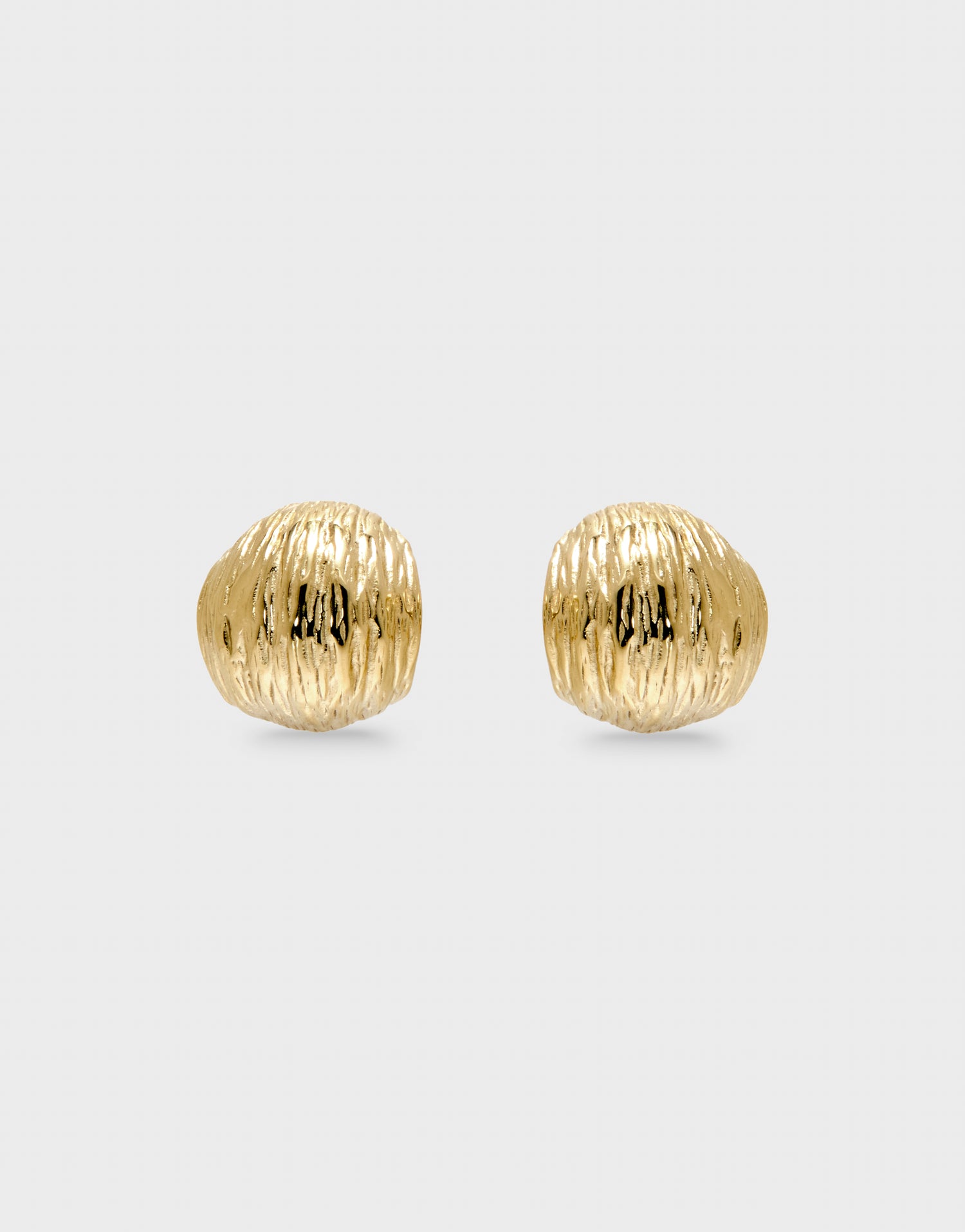 Pair of gold textured earrings on a light gray background