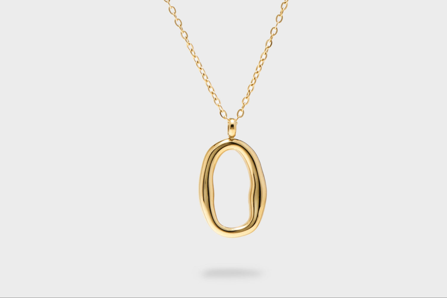 Gold necklace with a unique pendant on a white background