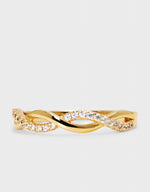 gold infinity ring with zirconia band in detail on grey background