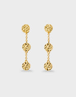 Gold earrings with spherical drops on a light gray background