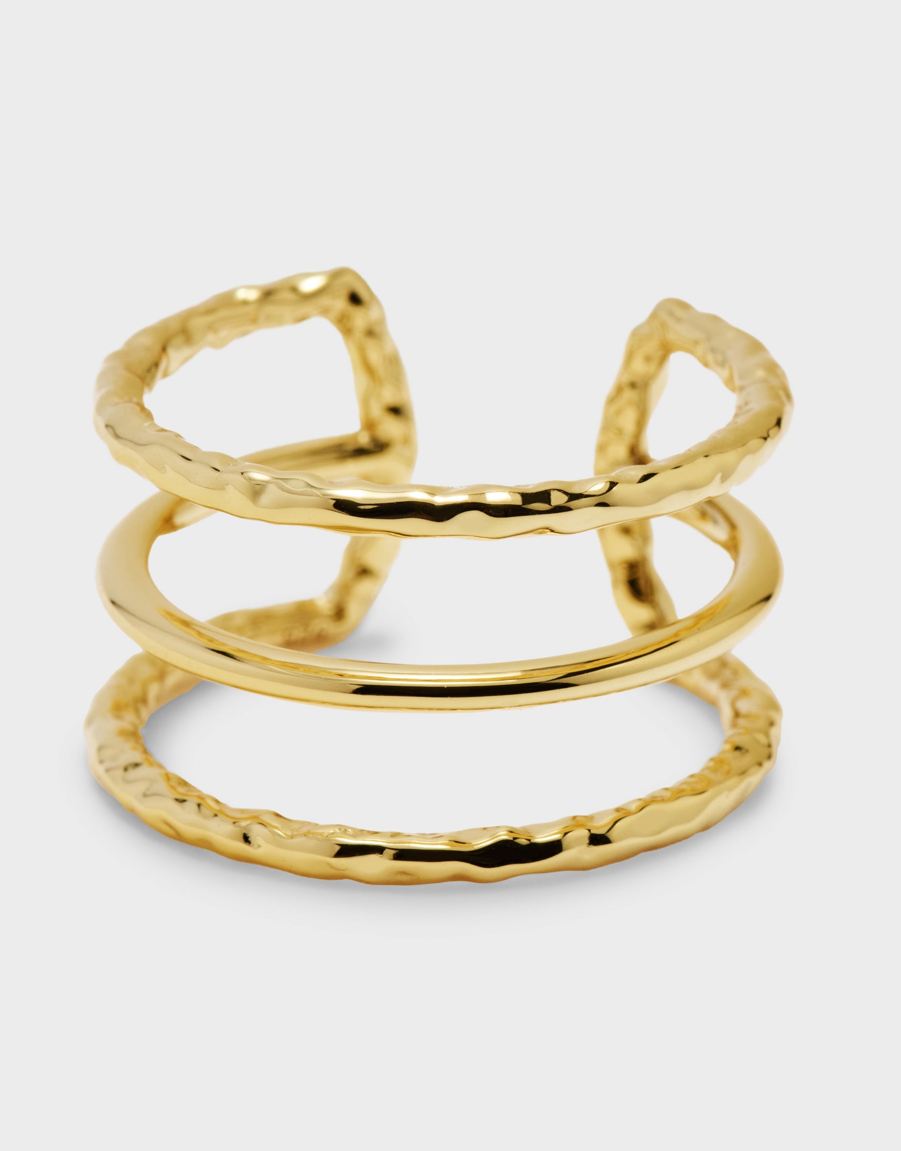 Gold ring with textured design on a light gray background