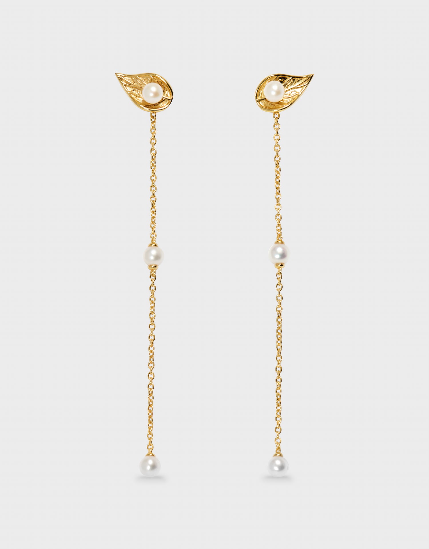 gold pearl earring drop on a grey background