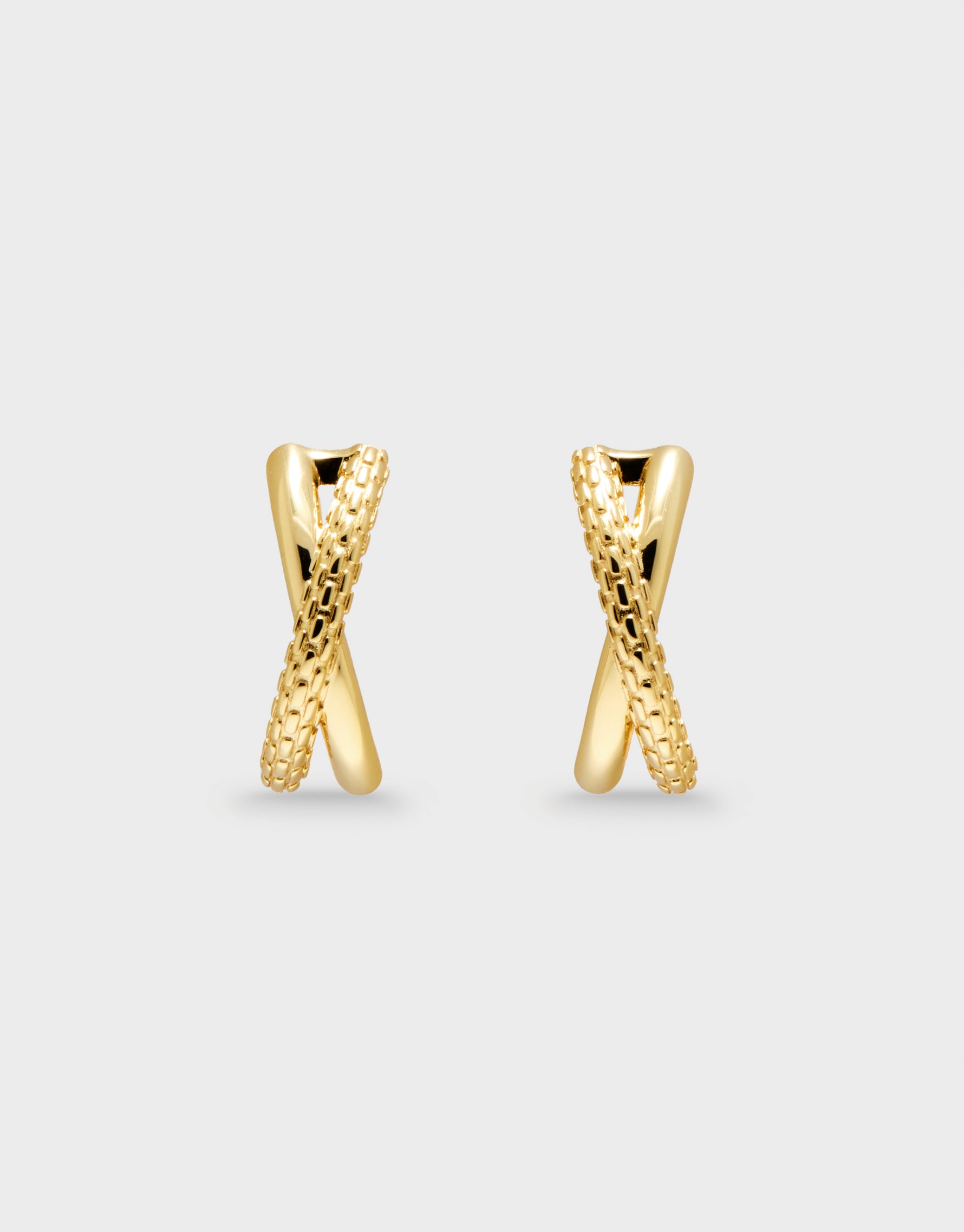 Pair of gold earrings on a light gray background